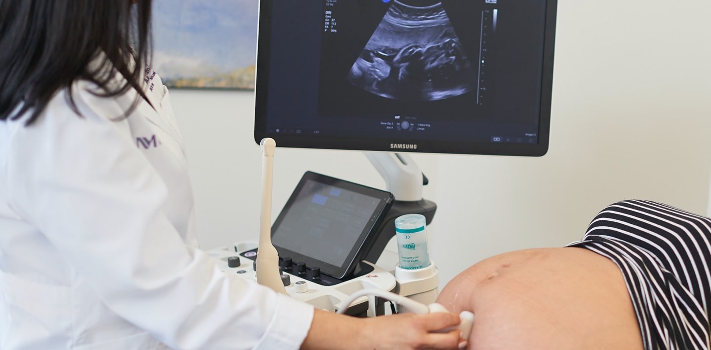 A technician performing an ultrasound on a pregnant woman