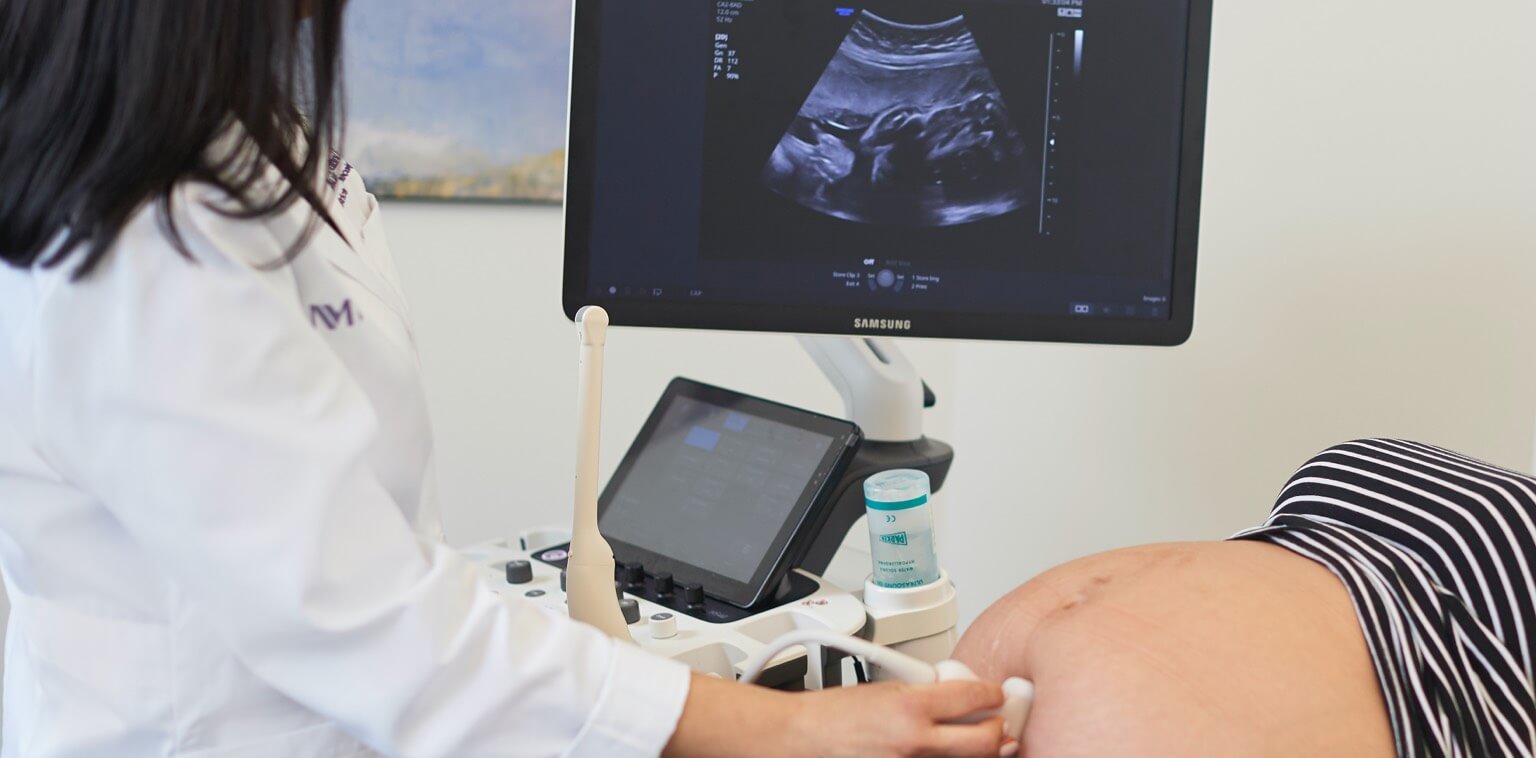 A technician performing an ultrasound on a pregnant woman